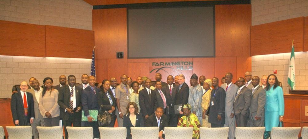 A group of people standing in front of a large screen.