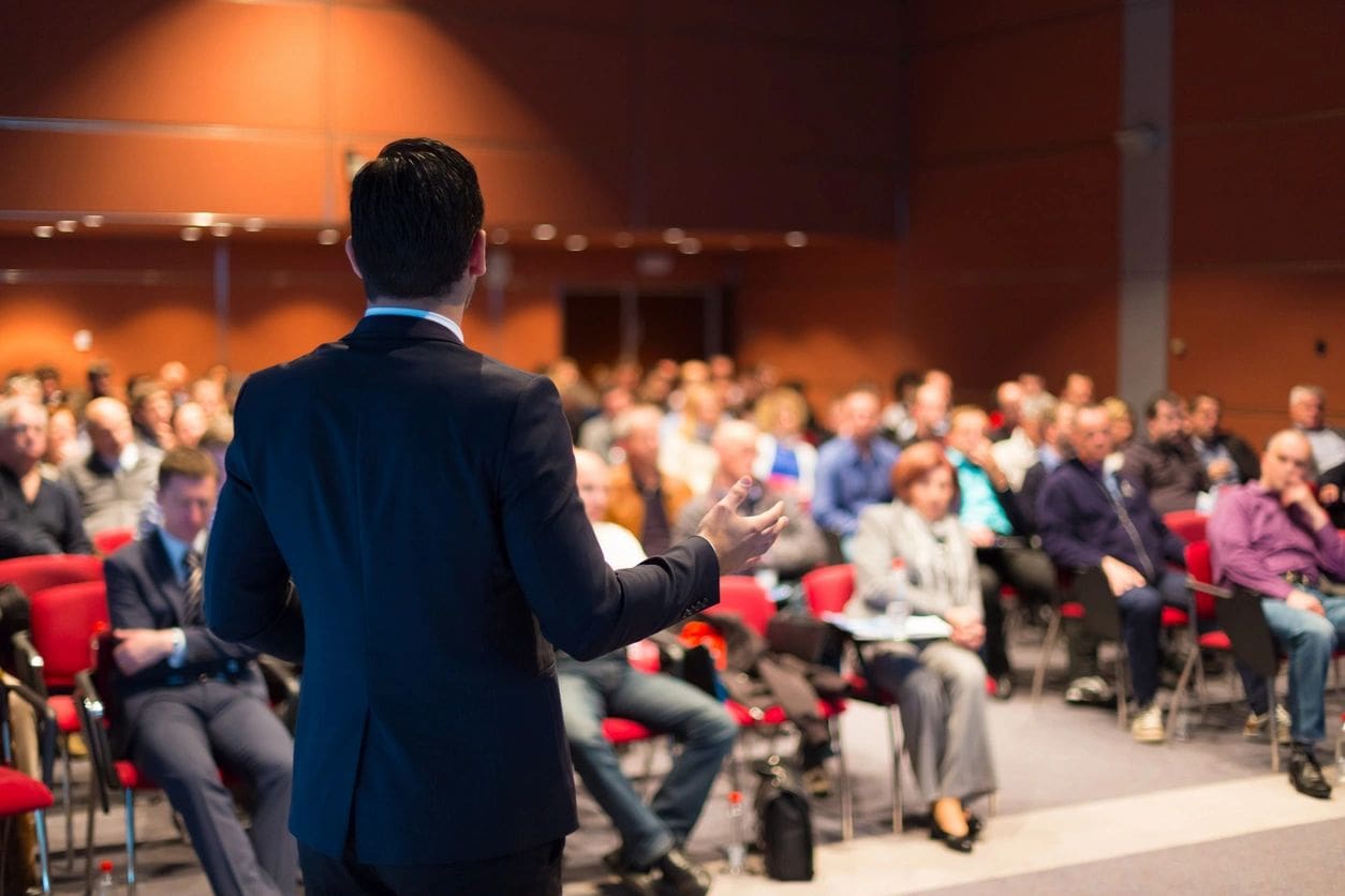 A man in a suit is giving a presentation.