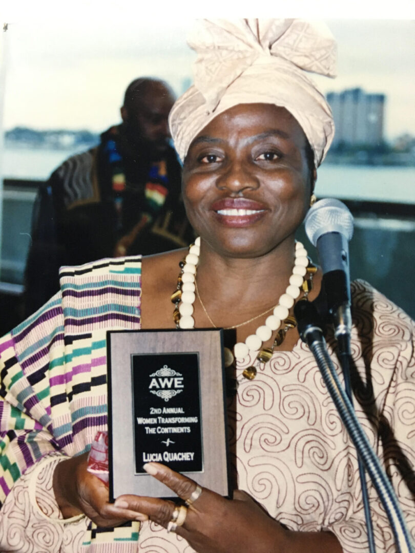 A woman holding an award and smiling.